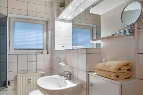 a white bathroom with a sink and a mirror at Ferienwohnung Tannenblick 3-1 in Oberhof