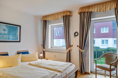 a bedroom with a bed and a chair and a window at Ferienwohnung Tannenblick 3-1 in Oberhof