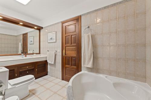 a bathroom with a tub and a toilet and a sink at Villasal in Playa Blanca