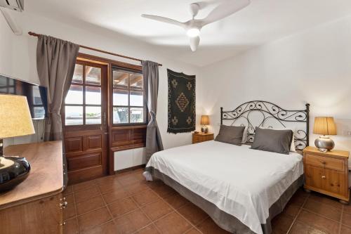 a bedroom with a bed and a ceiling fan at Villasal in Playa Blanca