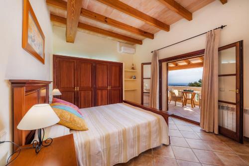 a bedroom with a bed and a view of the ocean at Turó de na Roca in S'Horta