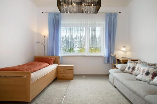 a bedroom with a bed and a couch and a window at Thaicenter Bodensee 2 in Friedrichshafen
