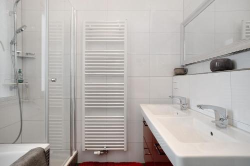 a white bathroom with a sink and a shower at Thaicenter Bodensee 2 in Friedrichshafen