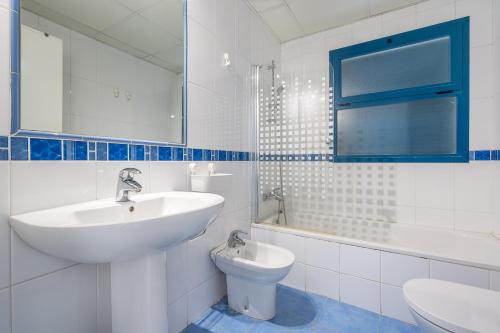 a white bathroom with a sink and a toilet at Piso Castell in Castell de Ferro
