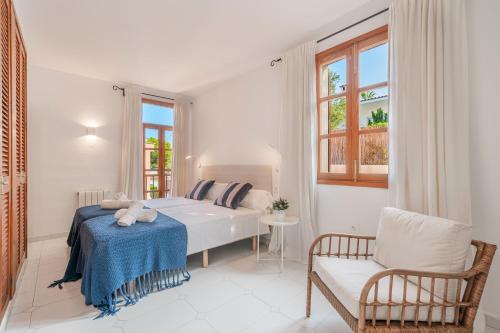 a white bedroom with a bed and a chair at Ca Na Luisa-Residential Area in Palmanova