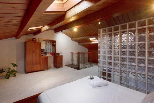 a bedroom with a white bed and a glass wall at Duplex India in Tacoronte