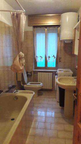 a bathroom with a tub and a toilet and a sink at Mansarda le Chateau in Aymavilles