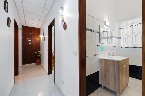 a bathroom with a sink and a hallway at Apartment T2 Malveiro in Odeceixe