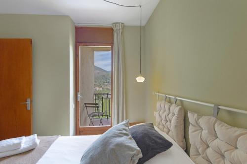 a bedroom with a bed and a view of a balcony at El Campanar in Sant Llorenç de Morunys