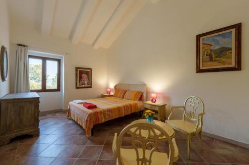 a bedroom with a bed and a table and chairs at Casa vacanza Macciunitta in Arzachena
