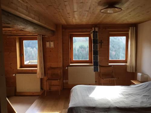 a bedroom with two windows and a bed in it at Chalet La Grangette in Abondance
