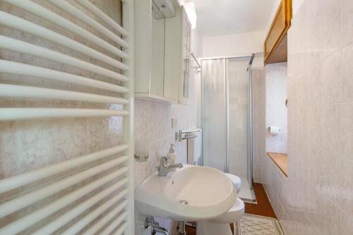 a white bathroom with a sink and a toilet at Affittacamere Angelina in San Pietro di Cadore