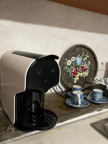 a black coffee maker sitting on a counter next to cups at Casa Do Mestre Lau in Terena