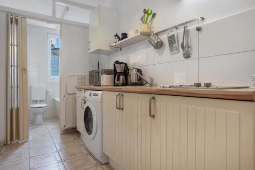 a kitchen with a sink and a washing machine at Ferienwohnung Bett Und Buch in Lychen