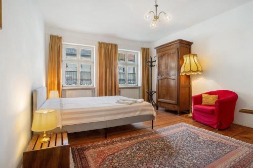 a bedroom with a bed and a red chair at Ferienwohnung Bett Und Buch in Lychen