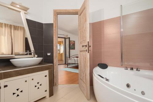 a bathroom with a tub and a sink at Seahouserent in Cannigione