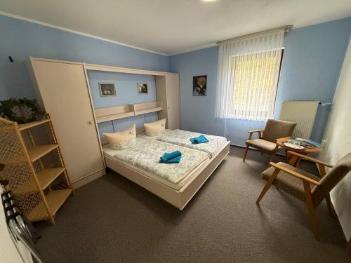 a bedroom with a bed and a table and a chair at Waldhotel Einstein in Kirchhundem