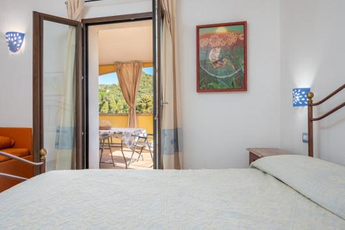 a bedroom with a bed and a view of a patio at Seahouserent in Cannigione