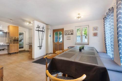 a dining room with a table and a kitchen at Ferienhaus alte Münze in Neuerburg