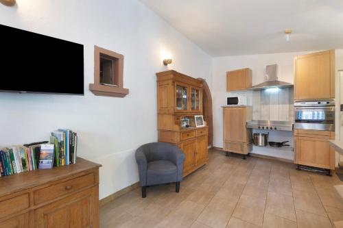 a kitchen with a tv and a chair in a room at Ferienhaus alte Münze in Neuerburg
