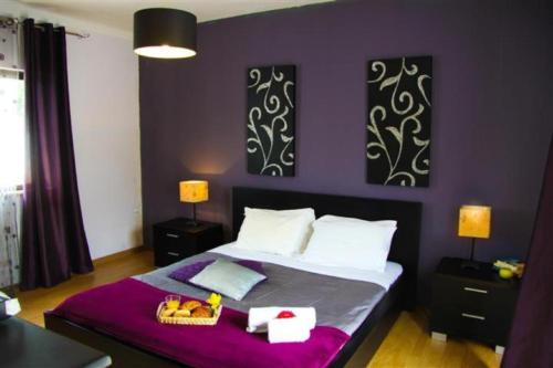 a bedroom with a large bed with purple walls at Fernandes Apartment in Carvoeiro
