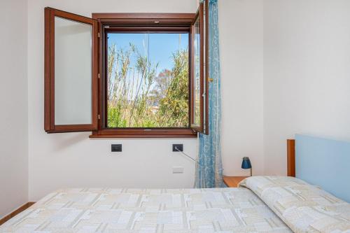 a bedroom with a bed and a window at Villetta Confortevole in San Teodoro