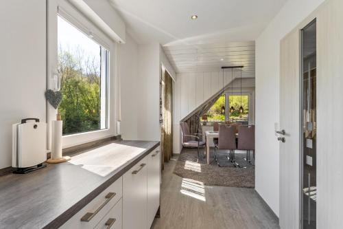 a kitchen with white cabinets and a large window at Landhaus Kramer Meine Cardplus inkl in Willingen