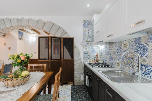 a kitchen with blue and white tiles and a sink at Ai Cannola - Calatafimi Segesta in Calatafimi