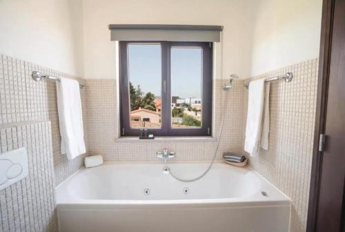 a bath tub in a bathroom with a window at Villa Laguna - Charmy Villa in Moncarapacho