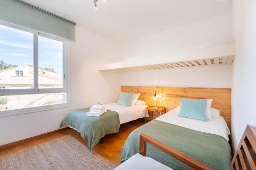 a room with two beds and a window at Mimosa in Alcudia
