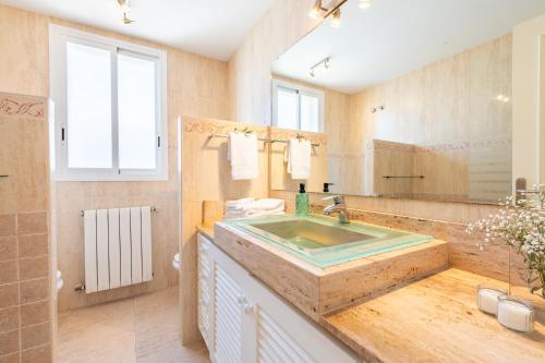 a bathroom with a sink and a large mirror at Mimosa in Alcudia