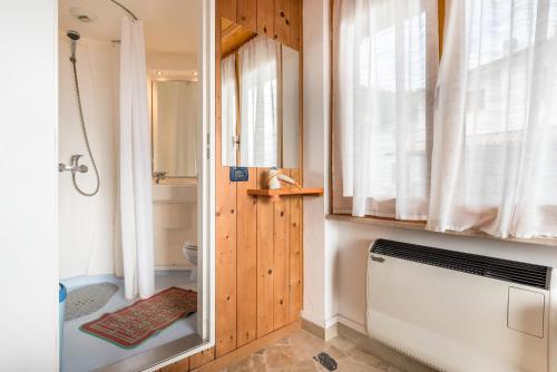 a bathroom with a tub and a toilet and a window at App Olivo Casa Demonti in Tignale