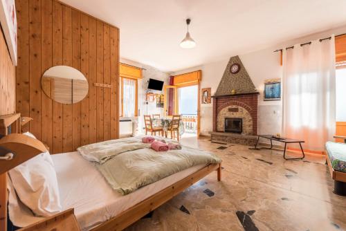 a bedroom with a large bed and a fireplace at App Olivo Casa Demonti in Tignale