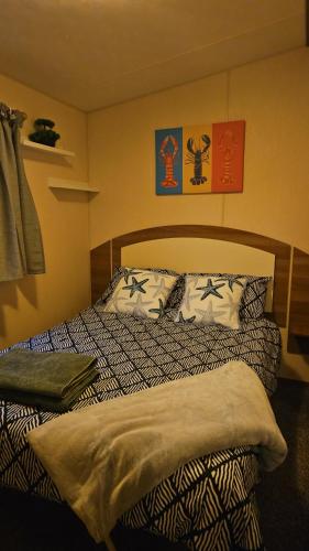 a bedroom with a bed with pillows on it at Seagulls Sunrise in Seasalter