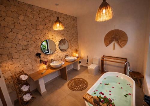 a bathroom with a sink and a tub and mirrors at Bahari Mirror Villas in Jambiani