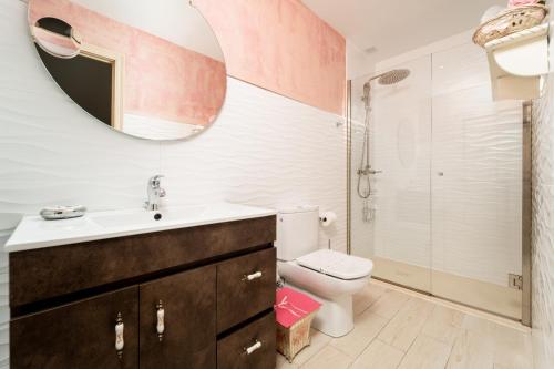 a bathroom with a sink and a toilet and a mirror at Hosteria Las Fuentes in Rubayo