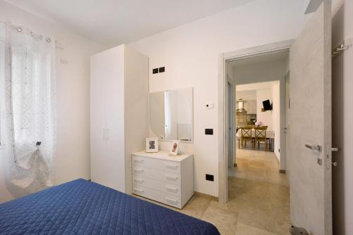 a white bedroom with a blue bed and a mirror at Antichi Ricordi - La Stalla in Marina di Andora