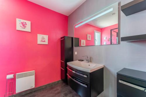 a pink bathroom with a sink and a mirror at Chalet en Provence in Sorgues
