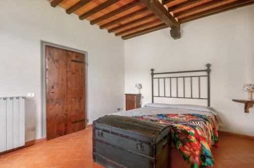 a bedroom with a bed and a wooden door at Universal Harmony - Capinera in Dicomano