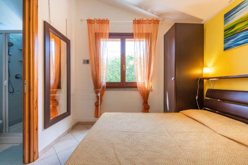 a bedroom with a bed and a window at Domixedda in Costa Rei