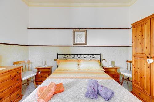 a bedroom with a bed with two purple socks on it at Casa Rosa in Fluminimaggiore