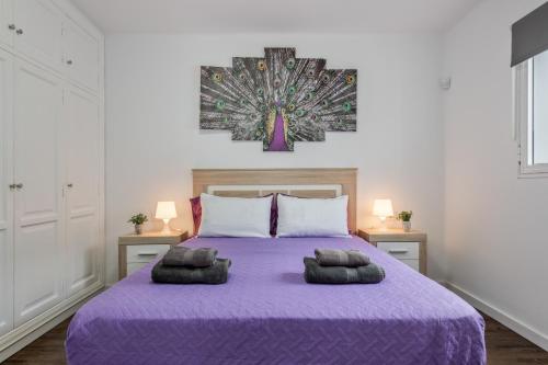 a bedroom with a purple bed with two pillows on it at Casa Barriguita 2 in Playa Blanca