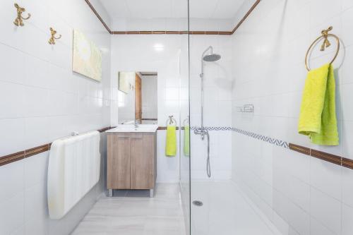 a white bathroom with a shower and a sink at Castellana in Bicorp