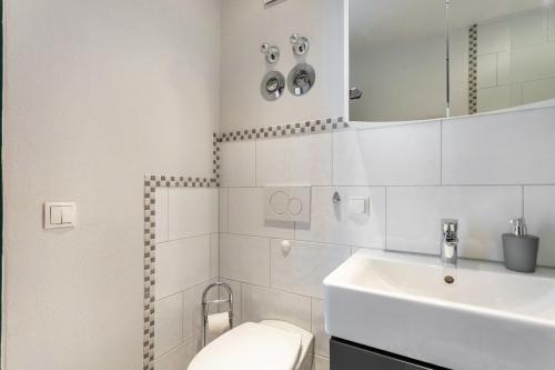 a white bathroom with a toilet and a sink at Ferienwohnung Seebruck in Seebruck