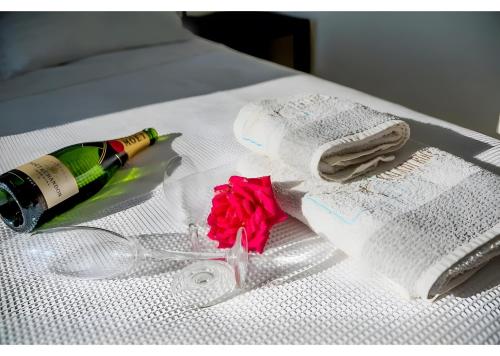 a bottle of champagne and a rose on a bed at Kaladi Rock Ammos in Avlemonas