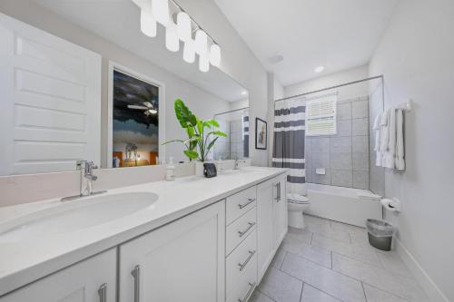 a white bathroom with a sink and a toilet at Serene Vibrant 4 Bdrm Villa with Games Room at Encore in Orlando