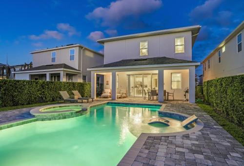 a swimming pool in front of a house at Serene Vibrant 4 Bdrm Villa with Games Room at Encore in Orlando