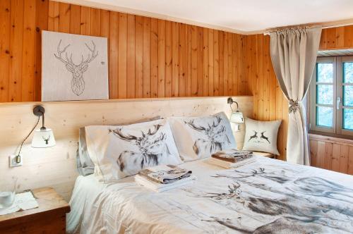 a bedroom with a bed with wood paneling at Sweet Somma Mountain Lodge 1 in San Guglielmo