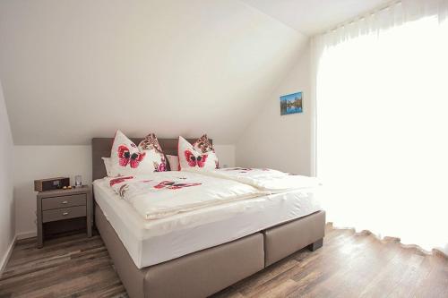 a bedroom with a bed with white sheets and pink pillows at Ferienhaus Am Rösslewald in Breitnau