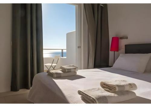 a bedroom with a bed with towels on it at Kaladi Rock Ammos in Avlemonas